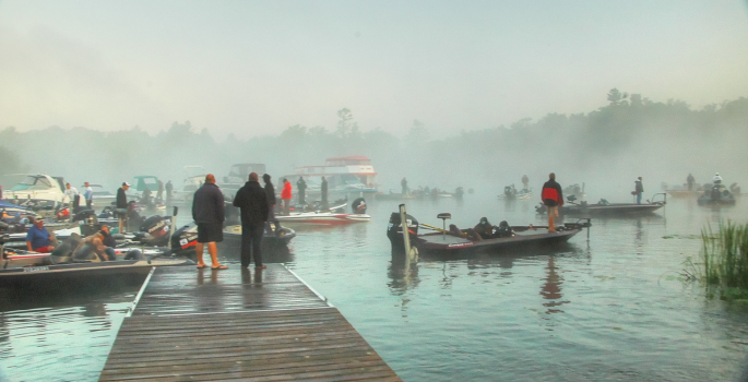 People fishing on boats and on a dock