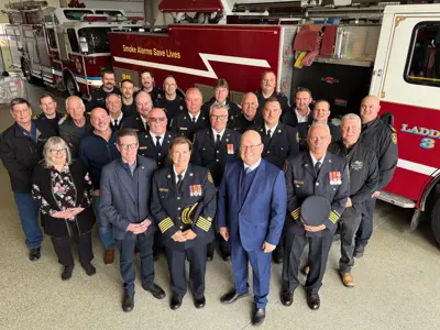 Group of Firefighters standing beside a fire truck
