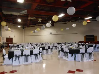 hall set up for a venue with white chair coverings 