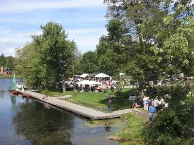 Ariel view of park space along the water with people and event tents