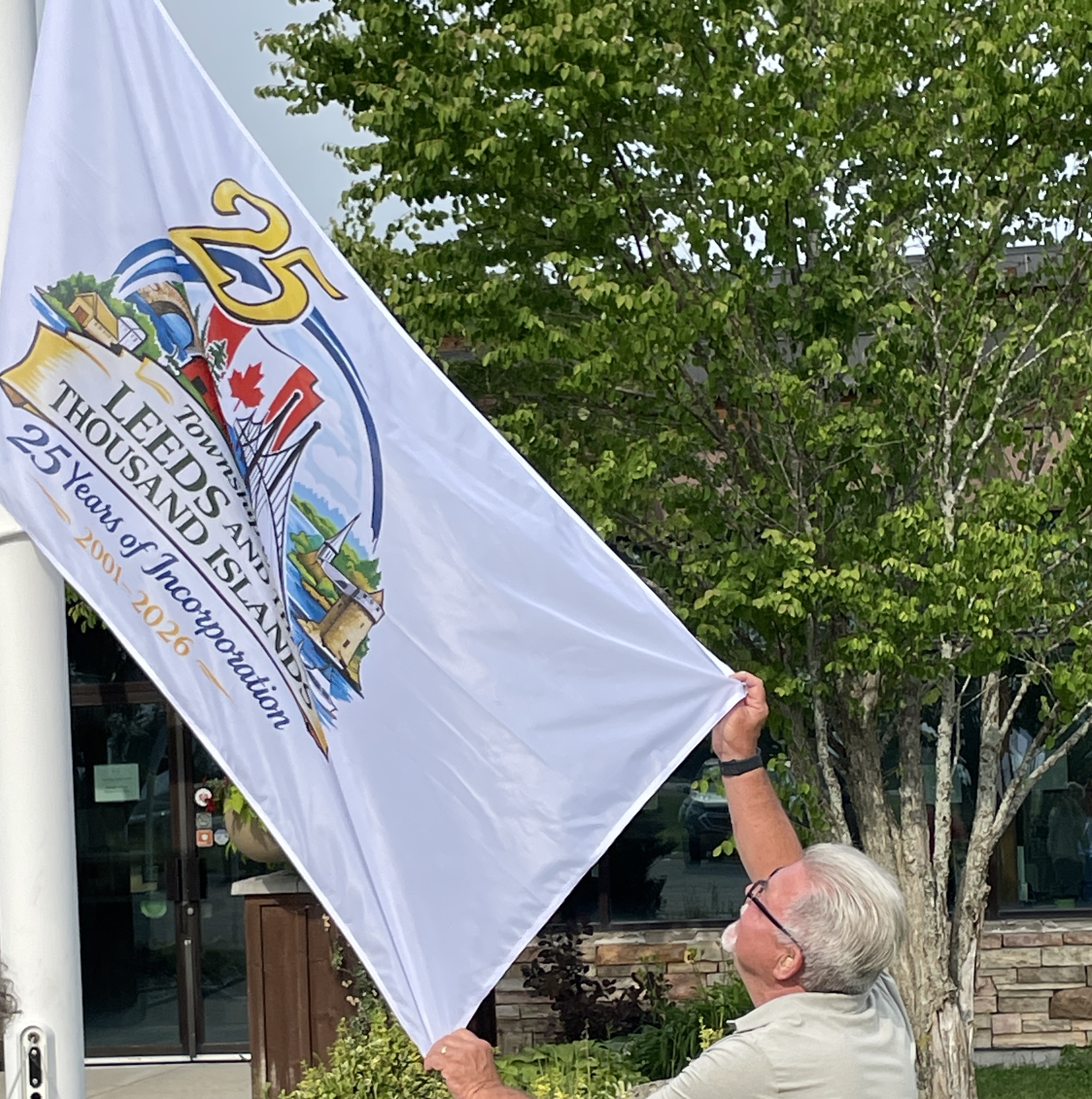 Man holding a flag being raised on a flag pole