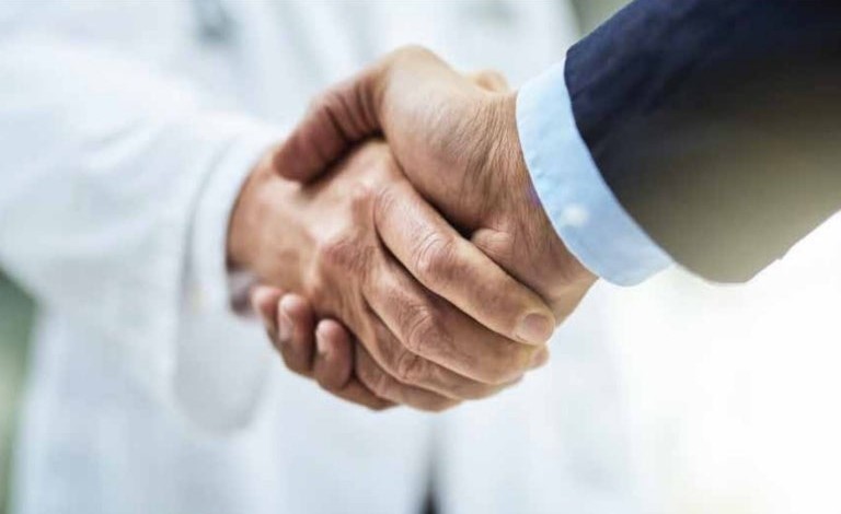 Hand shake between a Dr and a business person