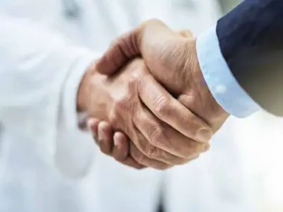 Hand shake between a Dr and a business person