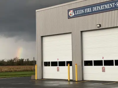 Fire station with view of two garage bay doors and a rainbow in the upper right corner