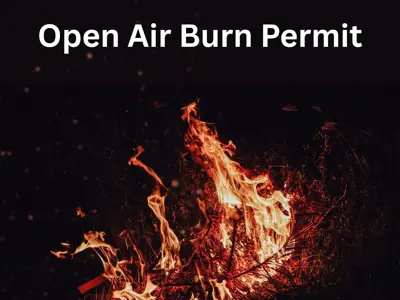 small fire of burning cedar branches on a black background with the text Open Air Burning