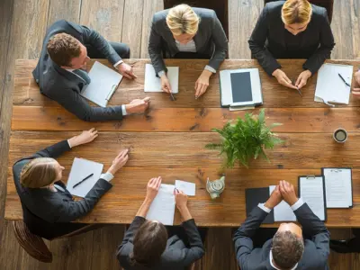 staff sitting around a board meeting table